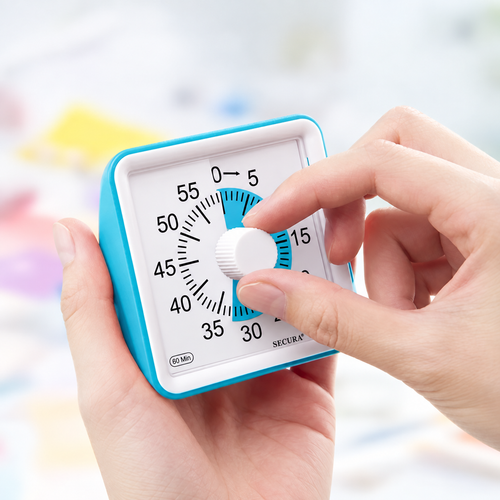 Hands holding the blue Secura visual timer and turning its white countdown dial.
